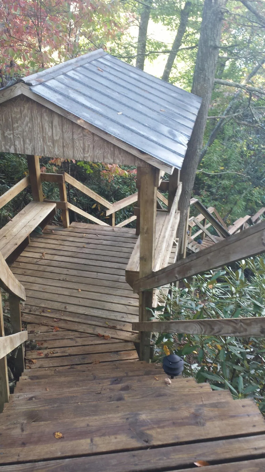 Metal roofed shelter over wooden steps on a wooded walkway — Skylight Repair & Installation work by our crew in Lehighton